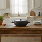 Black cast iron pot on a wooden kitchen counter with a modern kitchen in the background.